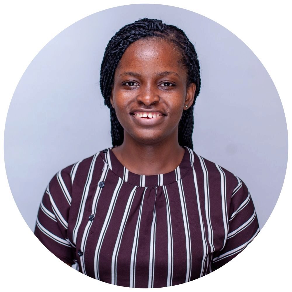 Nene Ibezim Headshot of a smiling person with braided hair, wearing a striped shirt, set against a plain background.